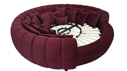 Urban Ashram round velvet movie bed in deep burgundy with plush cushions and a slatted wooden base for luxury lounging