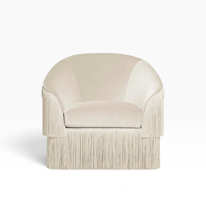 Urban Ashram Atelier fringe armchair in cream velvet with a curved backrest and elegant cascading side fringe detail.