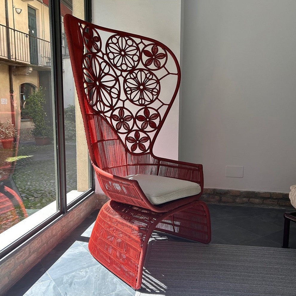 Urban Ashram Genevieve high-back armchair in red woven wicker with a floral backrest and a white seat cushion.