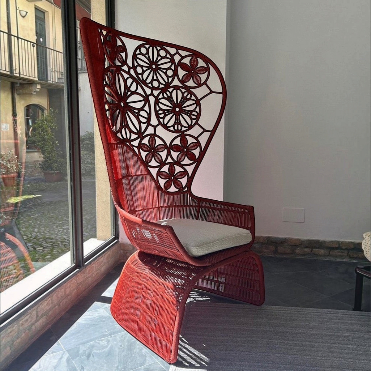 Urban Ashram Genevieve high-back armchair in red woven material with a floral backrest and a comfortable seat cushion.