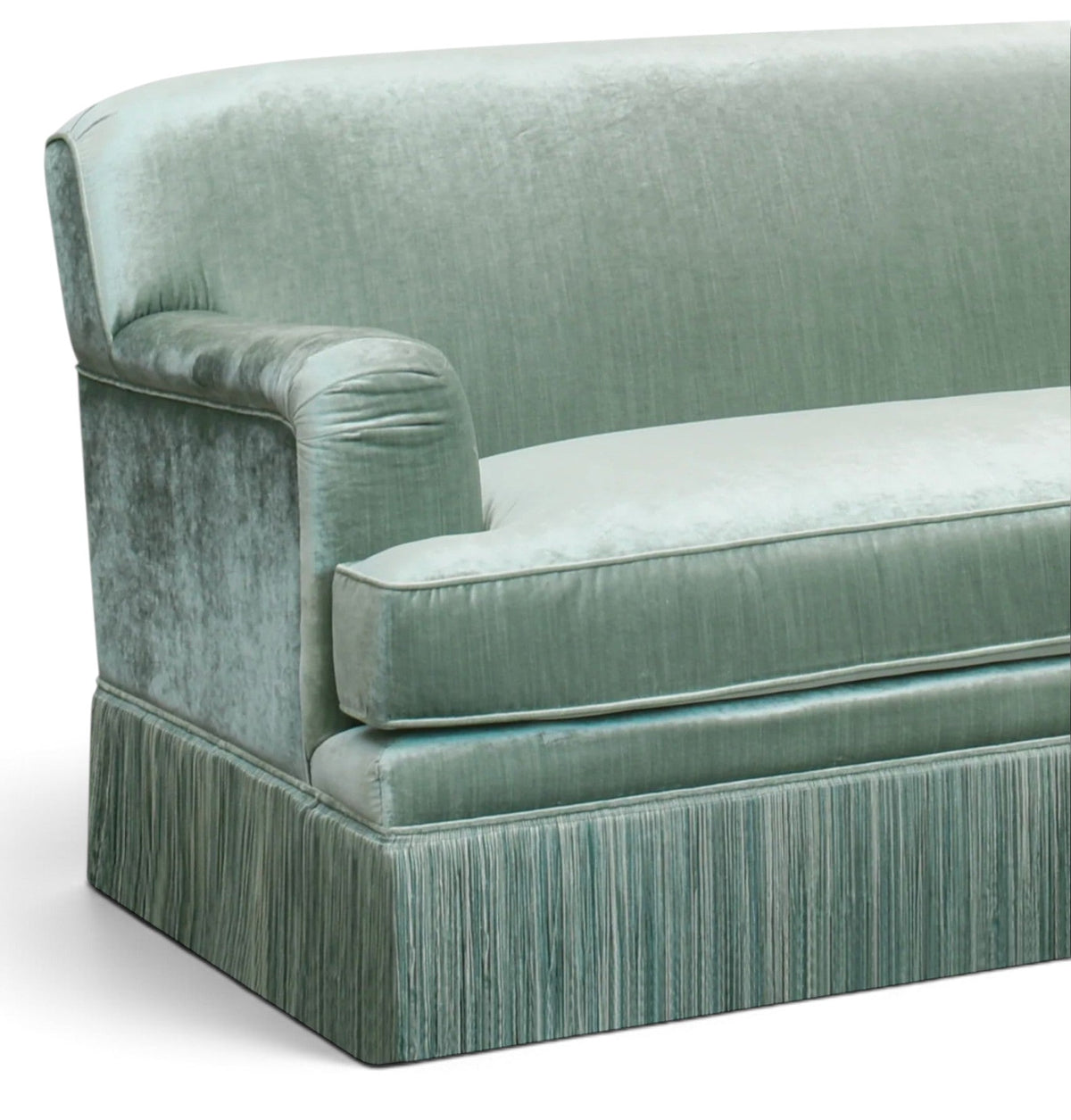 Urban Ashram vintage-style green velvet sofa with elegant tassel fringe and rounded armrest detail.