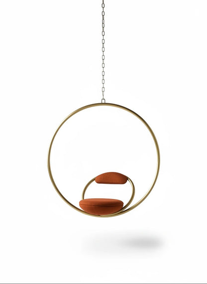 Urban Ashram Hanging Hoop Chair in brushed brass with red Kvadrat wool upholstery, featuring a geometric design.