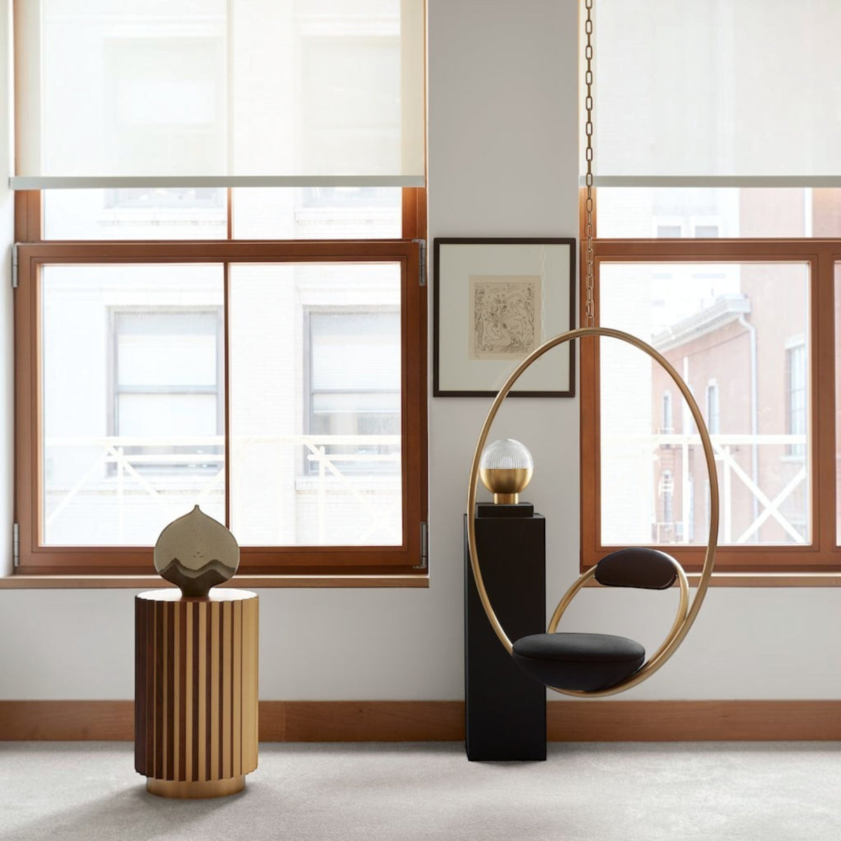 Urban Ashram Hanging Hoop Chair by Lee Broom featuring a brushed brass circular frame and dark upholstered seat