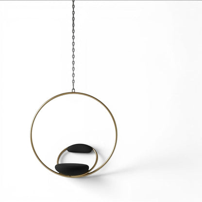 Urban Ashram Lee Broom Hanging Hoop Chair with a brushed brass circular frame and black upholstered seat and backrest.