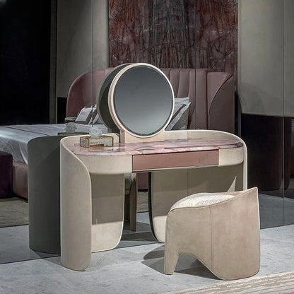 Urban Ashram Aveline vanity set with pink veined marble top, curved beige upholstered base, and matching stool.
