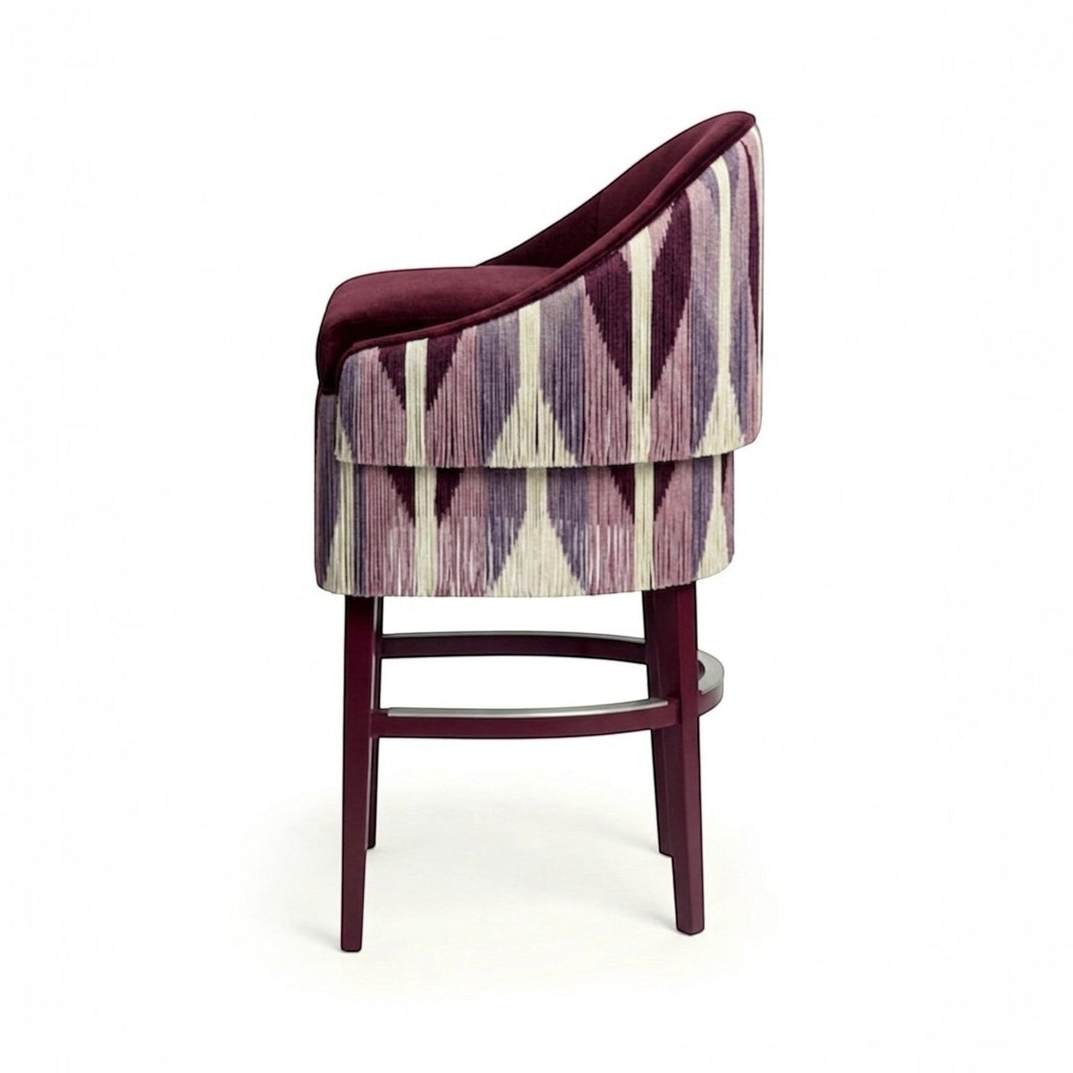 Urban Ashram Atelier Fringe Bar Stool with a plum velvet seat and geometric patterned fringe skirt on a wooden frame.