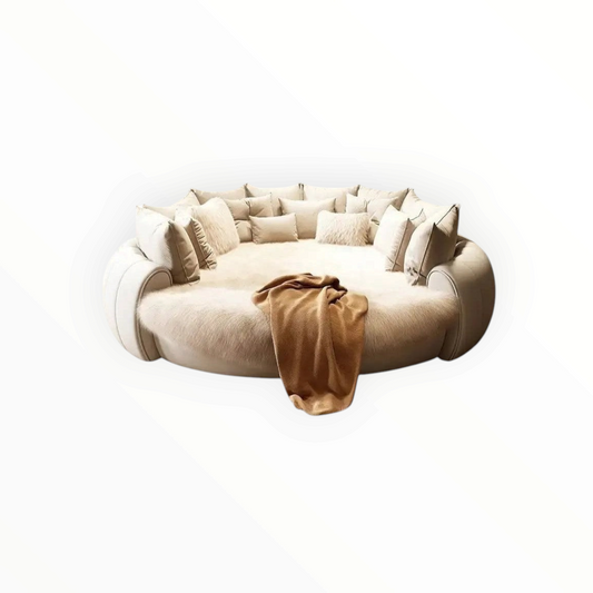 Urban Ashram Dream Lounger round movie bed in cream with plush faux fur and decorative cushions in a luxury room.