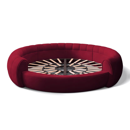Urban Ashram Dream Lounger round movie bed in deep red velvet with a circular slatted wooden base.