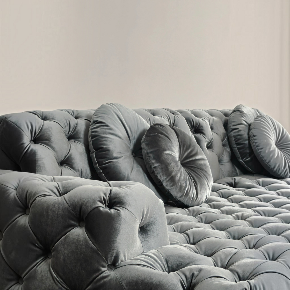 Urban Ashram Coco Miralda Chesterfield sofa in smoke grey velvet with deep button tufting and round accent pillows.