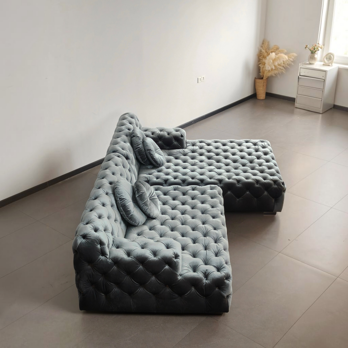 Urban Ashram Coco Miralda smoke grey velvet Chesterfield sectional sofa with deep button tufting and round cushions.