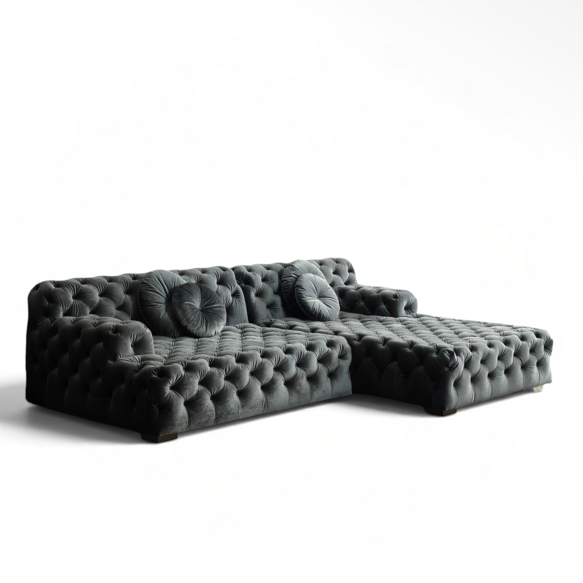 Urban Ashram Coco Miralda smoke grey velvet Chesterfield sectional sofa with deep button tufting in a modern room.