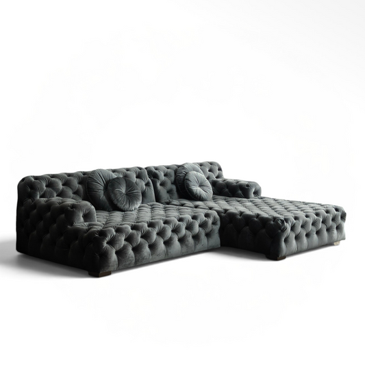 Urban Ashram Coco Miralda smoke grey velvet Chesterfield sectional sofa with deep button tufting in a modern room.